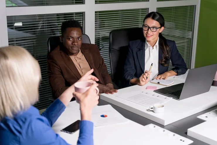 Four colleagues in a meeting with laptops open